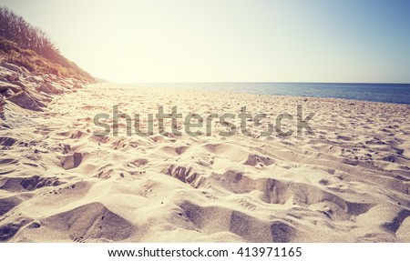 Vintage toned beach at sunset, focus on sand.