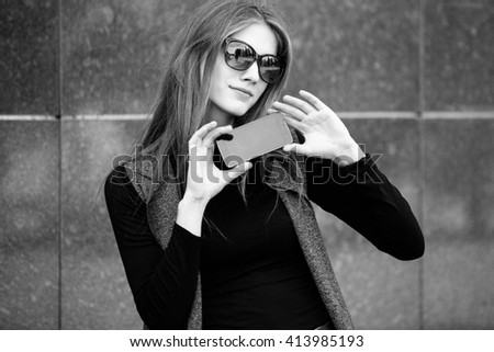 the phone holds a girl against a wall, black and white photography