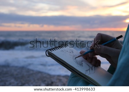 Drawing in a notebook on the waterfront. 