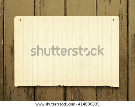 Close-up of one nailed blank old paper sheet frame on brown wooden boards background