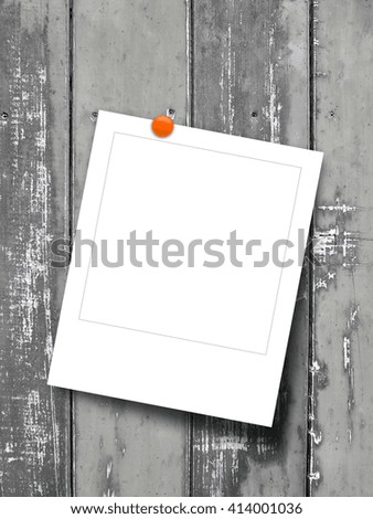Close-up of one blank square instant photo frame with pin on wooden background