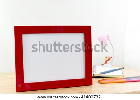 Blank photo frames on wooden table and white background.