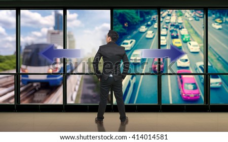 Businessman standing in doubt,thinking the two different choices of transportation for traffic jam with rush hour which indicated by arrows pointing in opposite direction, business decision concept
