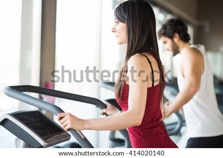 People running on treadmills in a gym