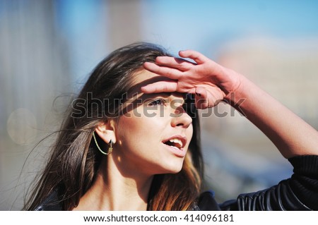 tired asian girl put her white hand to his forehead to shield his eyes from the sun shine, looks up and wonders. Hot face skin cover, beach heat stroke, hair care, uv sky bright light skincare concept Royalty-Free Stock Photo #414096181