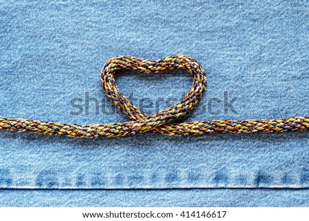 Love heart shaped rope on denim jeans background