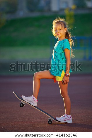 photo of cute little girl with skateboard outdoors