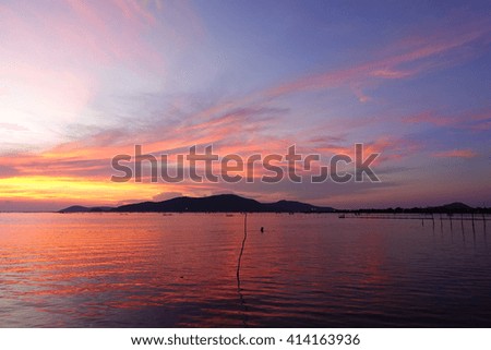 Long exposure shot over the Silhouette image of Island,the long concrete bridge,the lake and downtown at Songkhla Thailand during sunset.Motion blur, soft focus due to slow shutter speed.