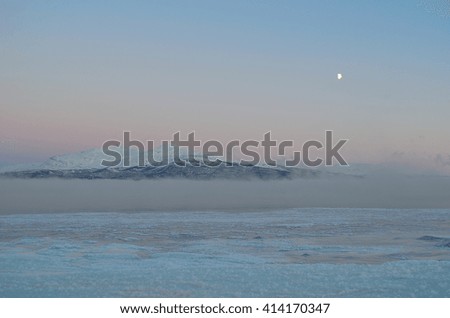 beautiful colorful dawn sky over frozen sea ice and thick ice fog