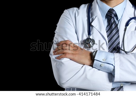 Male medicine therapeutist doctor hands crossed on his chest holding stethoscope in office isolated on black closeup. Medical help or insurance concept. Physician is waiting for patient to examine