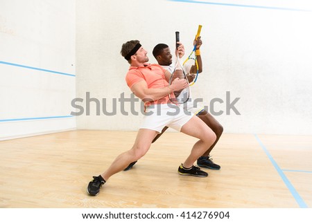 Picture of handsoe men playing squash on court. Young man playing guitars indoors. Sports and entertainment concepts.