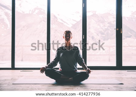 Young beautiful woman meditating while practicing yoga with mountain view in the background. Freedom concept. Calmness and relax, woman happiness. Toned picture