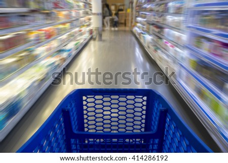 Shopping cart in a supermarket, with blurred shelves in the background