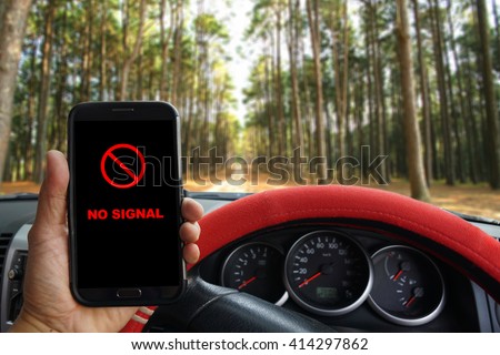 Man parking the car to use smartphone 
with showing NO SIGNAL icon, sunshine and evening sky in the forest, used for safety concept