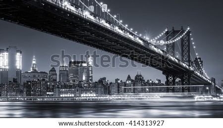 Manhattan Skyline and Manhattan Bridge At Night. Manhattan Bridge is a suspension bridge that crosses the East River in New York City. Long exposure for night image.