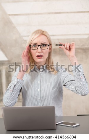 Freelance woman does not have enough memory for different data. Bautiful lady holding usb card near her memory in office.