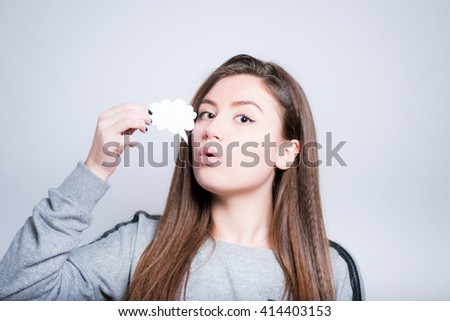 beautiful young woman is holding a sticker idea or thought, closeup isolated on a gray background