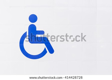 Blue disabled toilet sign on white ceramic wall background