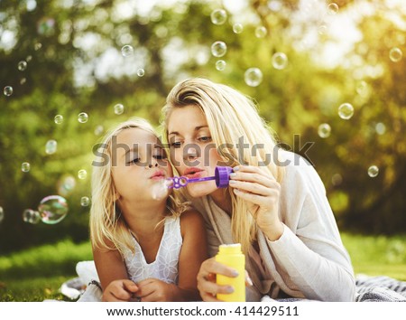Mother and daughter family time, blowing bubbles