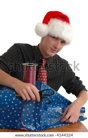 A young man in a santa hat wrapping a christmas present