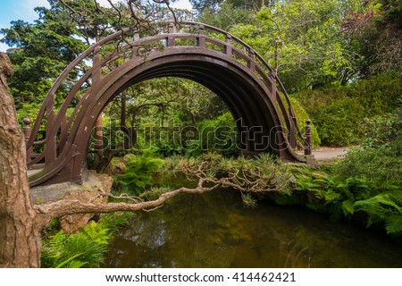 A wooden moon bridge in the Japanese tea garden at Golden Gate Park in San Francisco, California. Royalty-Free Stock Photo #414462421
