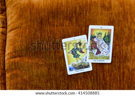 Fortune teller open the Tarot cards,THE FOOL ans THE EMPRESS in vintage style,on Orange velvet pillow.