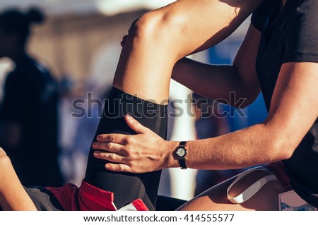 Sport therapist massaging leg of an athlete