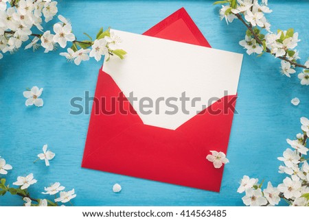 Flowers and envelope on wooden background 
