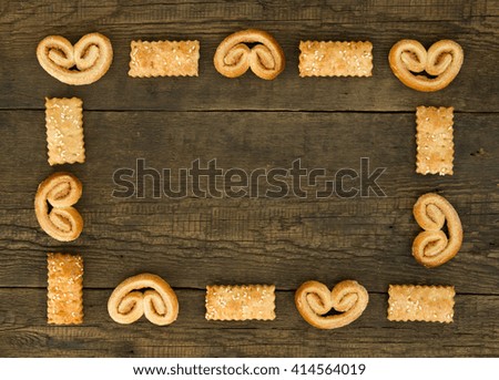 Frame from puff sweet pretzels with cinnamon  and cookies with  sesame on the wooden background