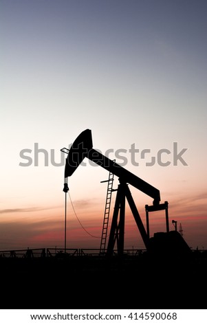 Sunset and silhouette of crude oil pump in the oilfield