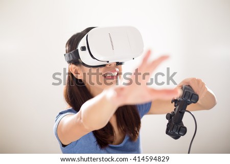 Excited Woman play video game wearing virtual reality