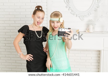 Two little girls doing selfie and show language