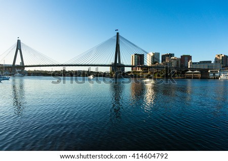 ANZAC Bridge with australian flags and Sydney CBD cityscape at dusk, Sydney, NSW, Australia