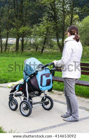Woman with pram while taking a walk