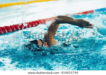 Freestyle swimming competitor in action Royalty-Free Stock Photo #414655744
