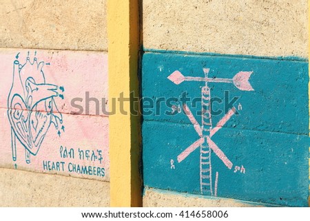 The school walls serve as outer blackboard displaying lessons for the students queuing at the schoolyard to enter their classrooms. Berahile-market for the salt from the Danakil. Afar region-Ethiopia.