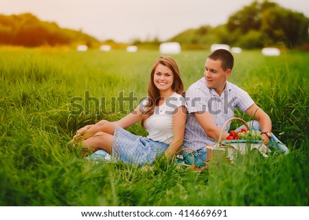 Man and woman on summer sunset picnic. Saturated picture