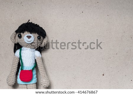 Crochet knitting cute girl doll on brown background