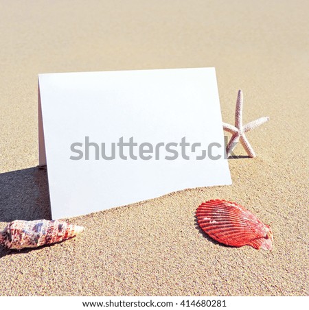 Blank white card or signboard with copy space. Beach scene with greeting card or white placard and beach decoration.          