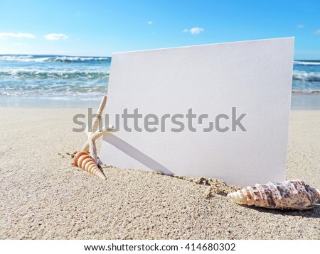 Blank white card or signboard with copy space. Beach scene with greeting card or white placard and beach decoration.          