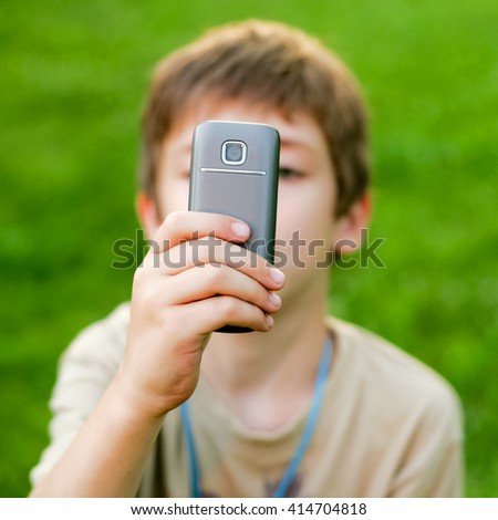 Young boy taking a picture with smart phone