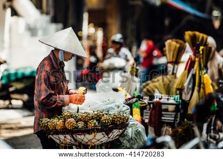 Silhouette of a man in the national Asian hat. Street vendor with a cart on the street. with pineapple tray Royalty-Free Stock Photo #414720283