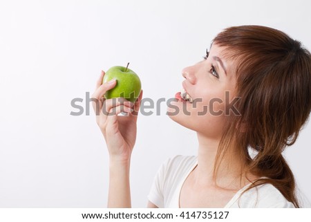 healthy asian woman looking up, hand holding green apple