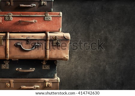 Vintage Pile Ancient Suitcases Form of Tower Design Concept Travel Luggage Traveler on Shabby Black Background Long Format Royalty-Free Stock Photo #414742630