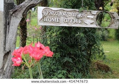 Old wooden HOME OFFICE sign in public park.