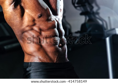 Male athlete lifts the dumbbell biceps in the gym Royalty-Free Stock Photo #414758149