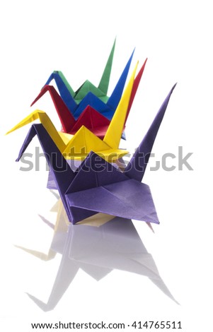 Traditional origami birds (cranes) made from colored paper isolated on white background