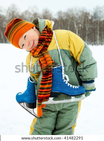cute little boy wearing warm winter clothes going ice skating
