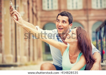 young brunette couple having fun together with music at park