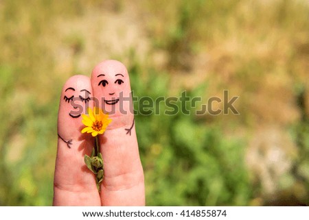 Drawn on the fingers of men with a flower. The concept of Dating. Family. Relationship